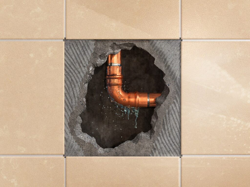 A leaking pipe behind a wall shows the need for Rhino Rooter’s pipe lining service, which fixes leaks with less mess.