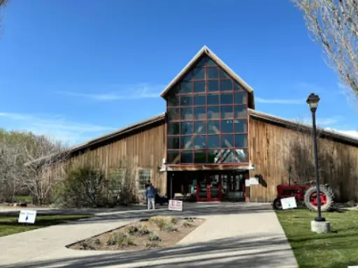 A Rhino Rooter worker stands outside a barn-style building, ready to help with hydro jetting services.