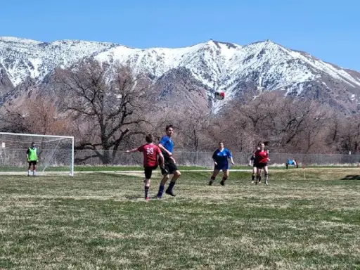 Teens enjoy a soccer game outside, showing active community life near The Wasatch Front, where Rhino Rooter serves local plumbing needs.