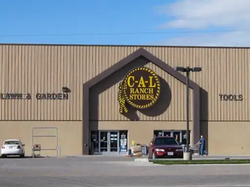 A skilled Rhino Rooter plumber walks toward C-A-L Ranch Stores, ready to help customers with plumbing needs.