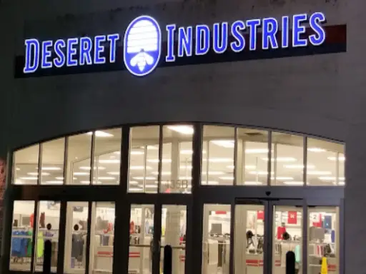 Rhino Rooter provides expert sewer repair services near a well-lit Deseret Industries thrift store at night.