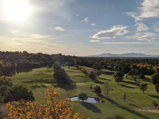 Rhino Rooter enjoys a peaceful golf course with trees, mountains, and a pond in The Wasatch Front after work.