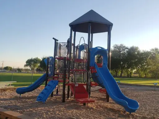 A colorful playground in a quiet park gives families and kids a place to have fun. Rhino Rooter provides plumbing services nearby.