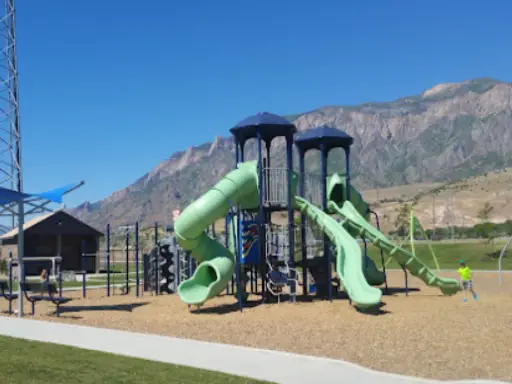 Children play on a playground with tall slides and climbing areas near the mountains served by Rhino Rooter.