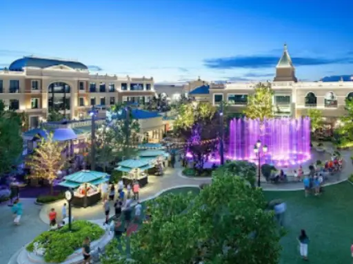 People enjoy a lively shopping plaza in the evening, surrounded by buildings that look clean after Rhino Rooter’s recent service.
