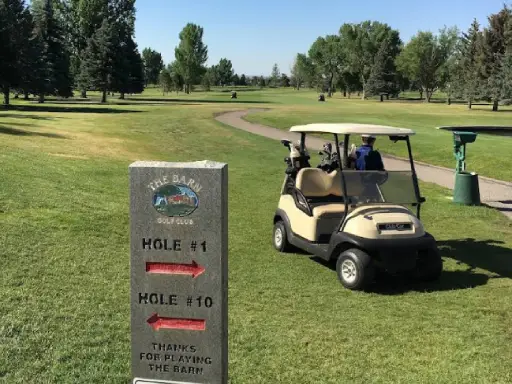 A golf cart is parked on grass by a stone sign for The Barn Golf Club. Rhino Rooter can help golfers or locals needing sewer repair in The Wasatch Front.