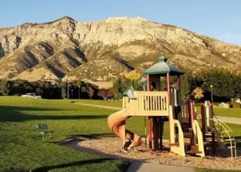 A Rhino Rooter plumber works near a playground in The Wasatch Front, helping families with pipe and sewer repairs.