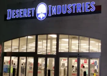 Rhino Rooter provides expert sewer repair services near a well-lit Deseret Industries thrift store at night.