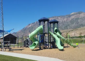 Children play on a playground with tall slides and climbing areas near the mountains served by Rhino Rooter.