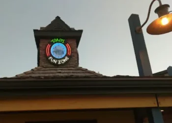 This image shows a fun place called Toads Fun Zone, with a glowing colorful sign outside. A streetlamp adds light next to the entrance, making it look welcoming for families or those needing Rhino Rooter services in The Wasatch Front.