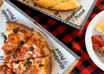 A table with pizza and cheesy breadsticks is ready for Rhino Rooter team members to enjoy after a hard day of plumbing work.